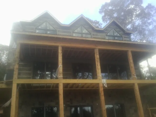 Dormers and porch framing on a large log home under construction — Roof Coating work by our crew in Westlake